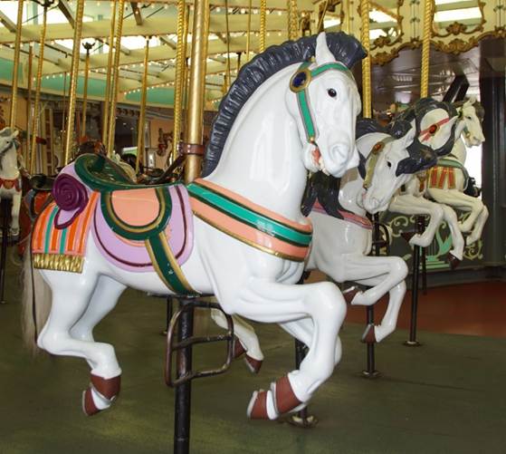 A group of horses on a merry go round
Description automatically generated