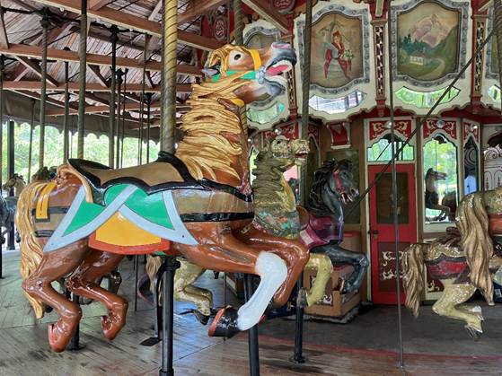 A carousel with horses on a wooden floor

AI-generated content may be incorrect.