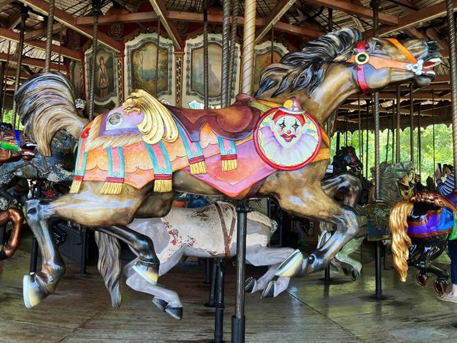 A carousel with horses and a person in the background

AI-generated content may be incorrect.