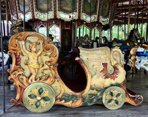 A carousel with a horse drawn carriage

AI-generated content may be incorrect.