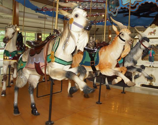 A group of horses on a merry go round
Description automatically generated
