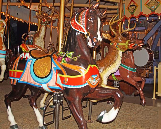 A group of horses on a merry go round

Description automatically generated