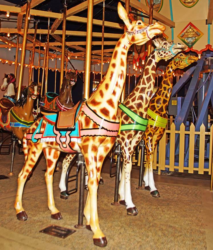A group of giraffes on a merry go round
Description automatically generated