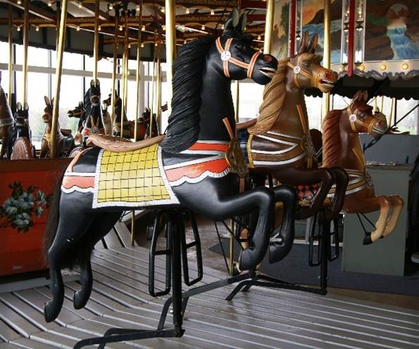 A group of horses on a merry go round
Description automatically generated