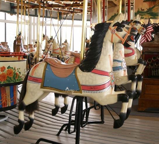 A carousel with horses and flags
Description automatically generated