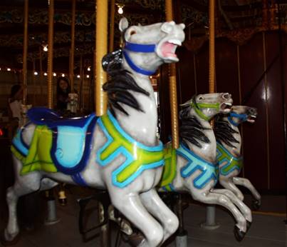 A group of horses on a merry go round

Description automatically generated