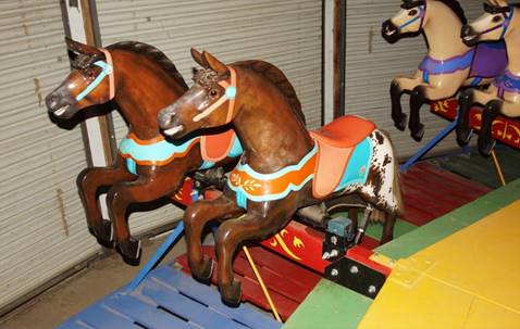 A group of horses on a carousel

Description automatically generated