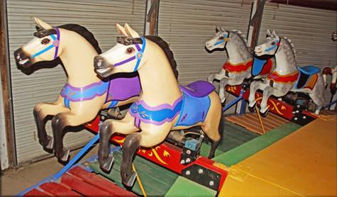 A group of horses on a carousel

Description automatically generated