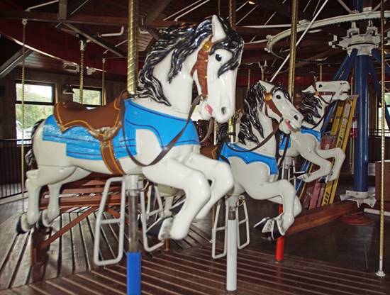 A group of horses on a merry go round

Description automatically generated