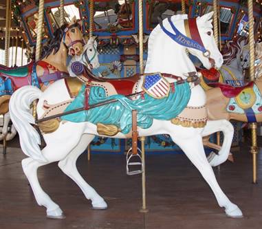 A person standing in front of a carousel horse

Description generated with high confidence