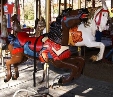 A large red chair in front of a carousel
Description generated with high confidence