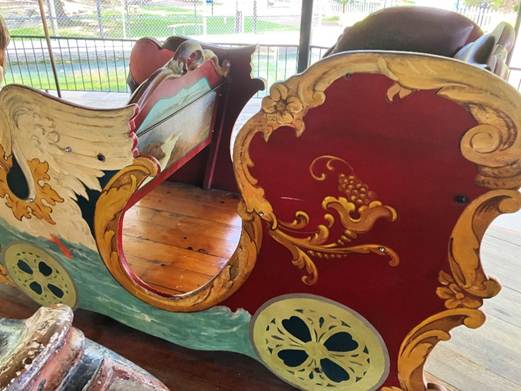 A painted wooden carriage with a horse drawn carriage
AI-generated content may be incorrect.