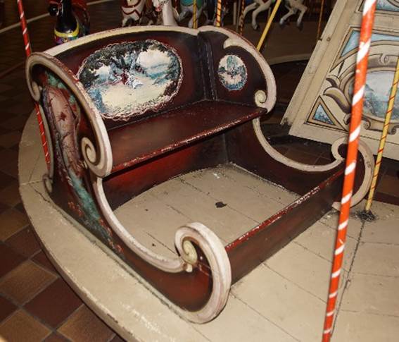 A wooden sleigh with a painting on it

Description automatically generated