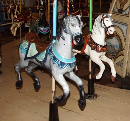 A group of horses on a merry go round

Description automatically generated
