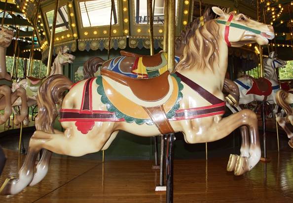 A horse statue in front of a carousel

Description automatically generated