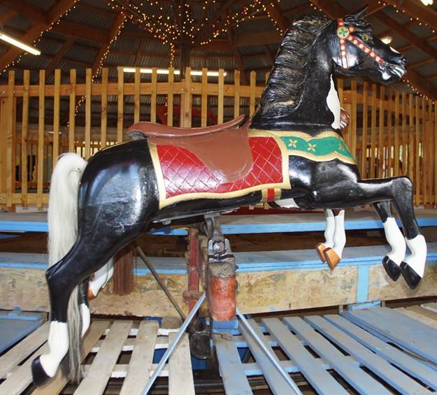 A horse statue in front of a wooden chair

Description automatically generated
